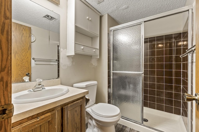 6007 Covington Ter, Minnetonka, MN 55345 - bathroom featuring a textured ceiling, a shower stall, toilet, and vanity
