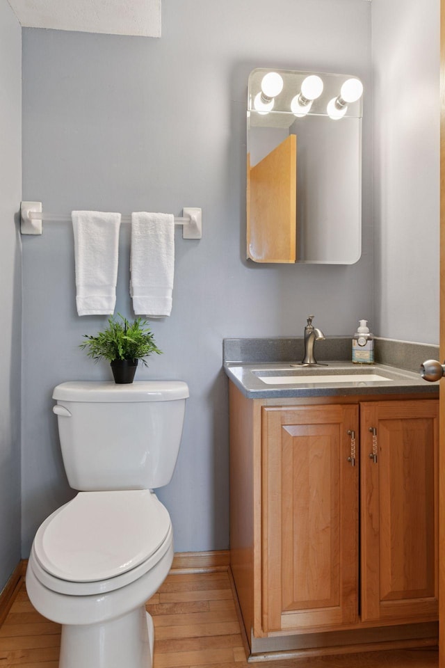 2452 Black Lake Rd, Spring Park, MN 55384 - half bath with toilet, wood finished floors, vanity, and baseboards