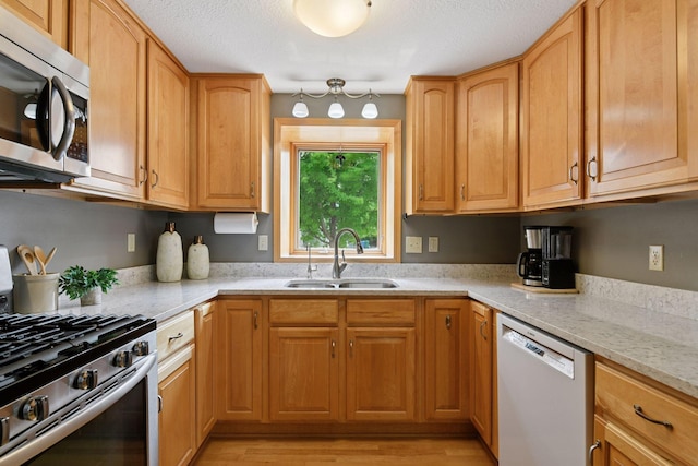 2452 Black Lake Rd, Spring Park, MN 55384 - kitchen featuring stainless steel appliances, a sink, light stone countertops, and light wood finished floors