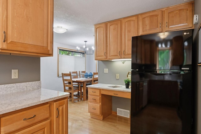2452 Black Lake Rd, Spring Park, MN 55384 - kitchen with freestanding refrigerator, light wood-style floors, a chandelier, light stone counters, and a textured ceiling