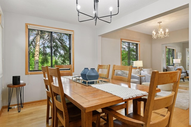 2452 Black Lake Rd, Spring Park, MN 55384 - dining area with a chandelier, light wood finished floors, and baseboards