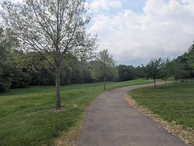 view of community with a yard and a wooded view