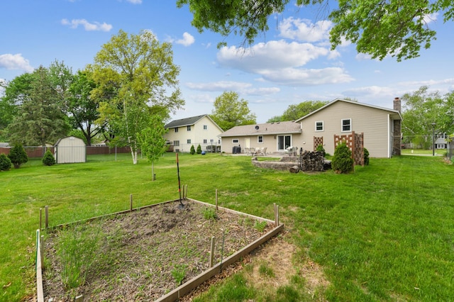 view of yard with a garden, a shed, and an outdoor structure