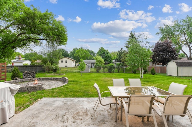 view of patio featuring an outdoor fire pit, a shed, an outbuilding, and outdoor dining space