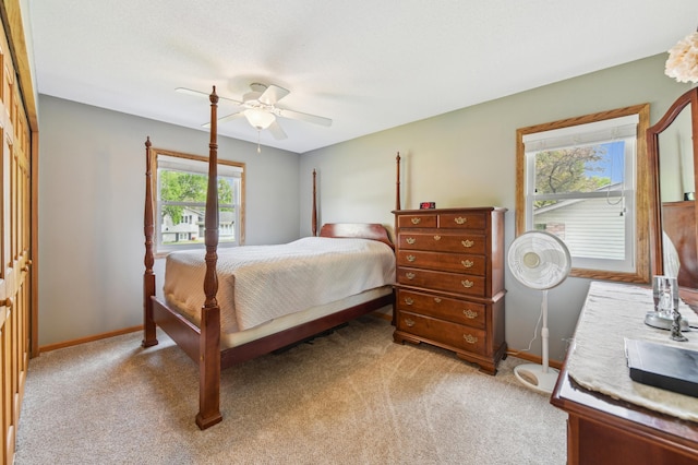 bedroom featuring light colored carpet, baseboards, and ceiling fan