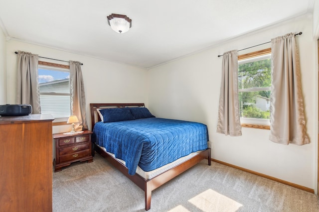 carpeted bedroom featuring baseboards and crown molding