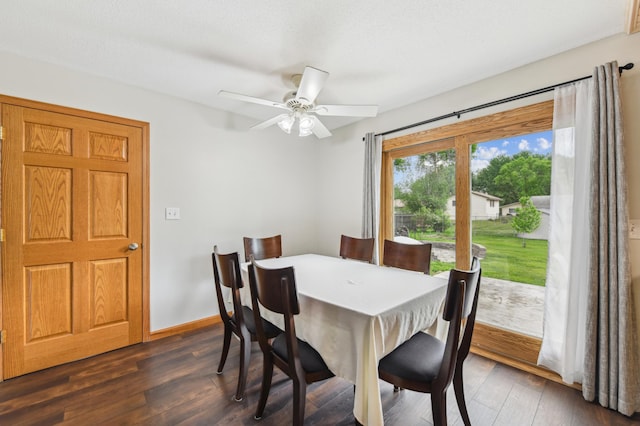 dining room featuring dark wood finished floors, a ceiling fan, and baseboards