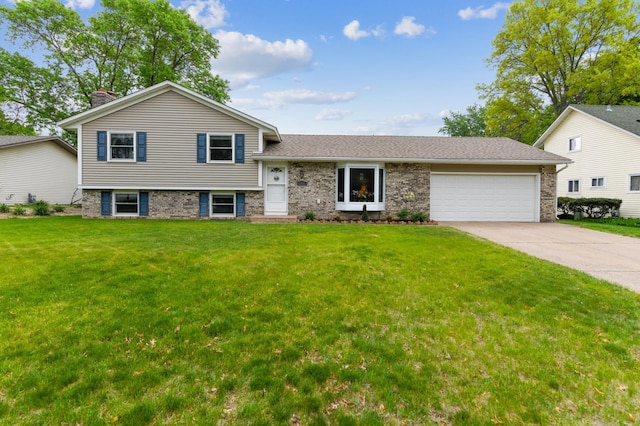 tri-level home with a garage, driveway, a front yard, and brick siding