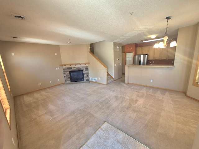 15437 Frost Path Unit 1507, Apple Valley, MN 55124 - unfurnished living room featuring a textured ceiling, a glass covered fireplace, light carpet, a chandelier, and baseboards