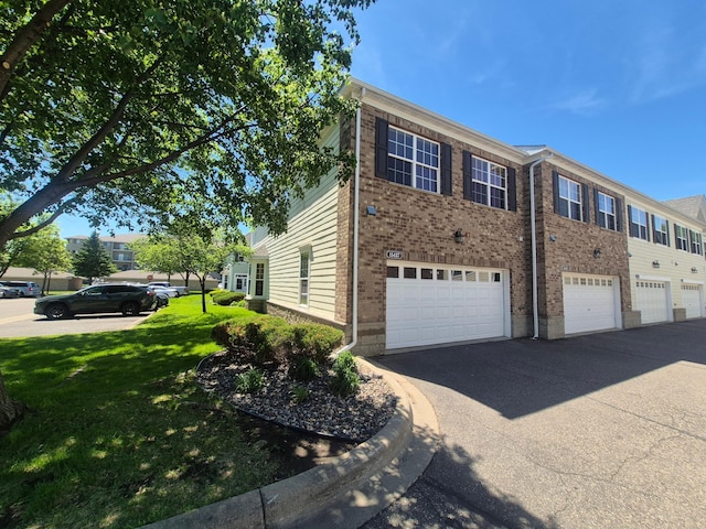 15437 Frost Path Unit 1507, Apple Valley, MN 55124 - view of side of home with brick siding, driveway, a yard, and an attached garage