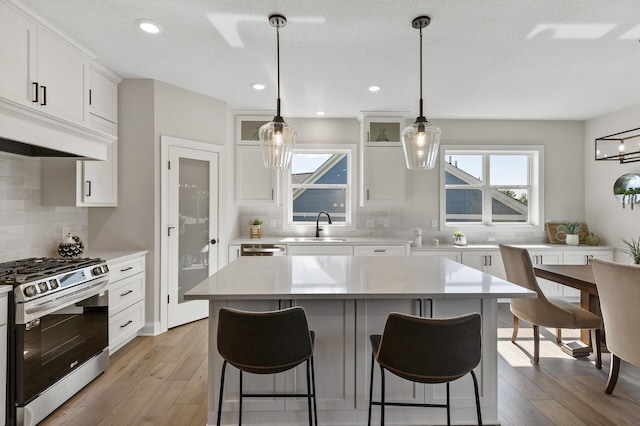 15587 Hampshire Ln, Savage, MN 55378 - kitchen featuring appliances with stainless steel finishes, backsplash, light countertops, a sink, and a kitchen breakfast bar