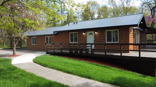 3245 Laketown Rd, Sturgeon Lake, MN 55783 - chalet / cabin with faux log siding, a wooden deck, metal roof, and a front yard