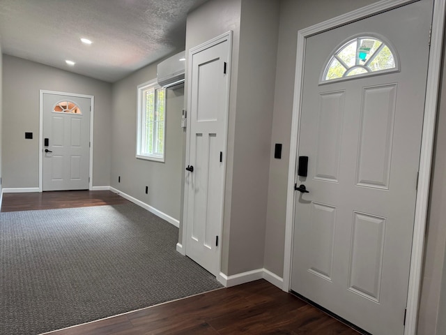 3245 Laketown Rd, Sturgeon Lake, MN 55783 - entrance foyer featuring a wall mounted AC, baseboards, and dark wood finished floors