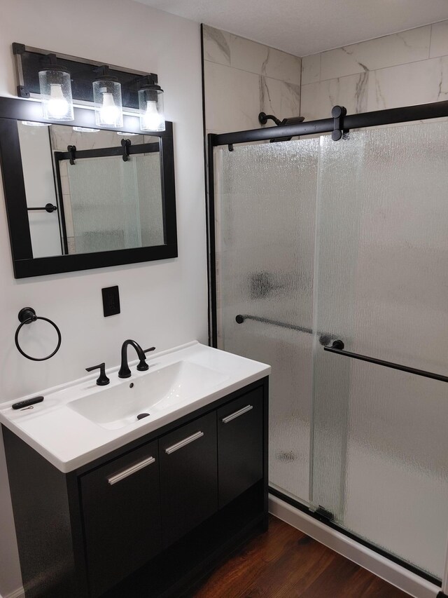 3245 Laketown Rd, Sturgeon Lake, MN 55783 - full bathroom with vanity, a shower stall, and wood finished floors