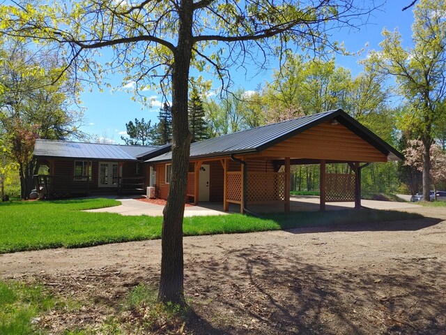 3245 Laketown Rd, Sturgeon Lake, MN 55783 - view of front facade featuring a front lawn, metal roof, a carport, and a standing seam roof