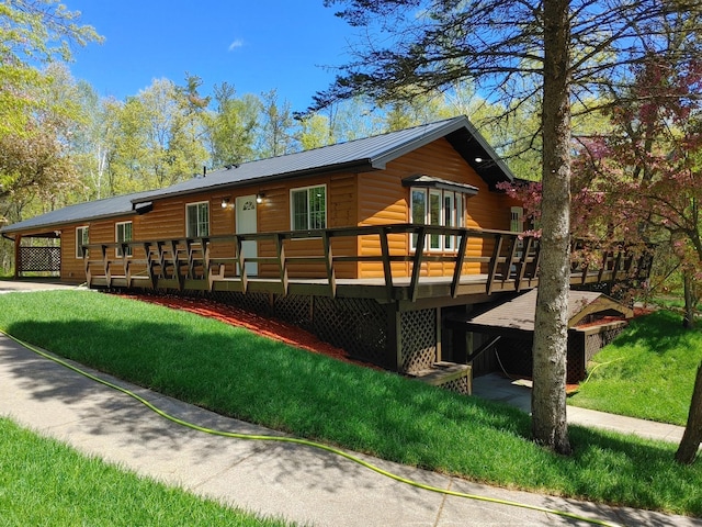 3245 Laketown Rd, Sturgeon Lake, MN 55783 - back of property with faux log siding, a wooden deck, a lawn, and metal roof
