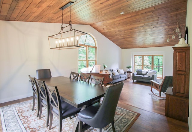 10551 Shore Dr, Merrifield, MN 56465 - dining area featuring vaulted ceiling, wood ceiling, a chandelier, dark wood-type flooring, and baseboards