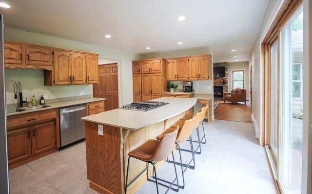 10551 Shore Dr, Merrifield, MN 56465 - kitchen with stainless steel appliances, a center island, light countertops, a kitchen breakfast bar, and a fireplace