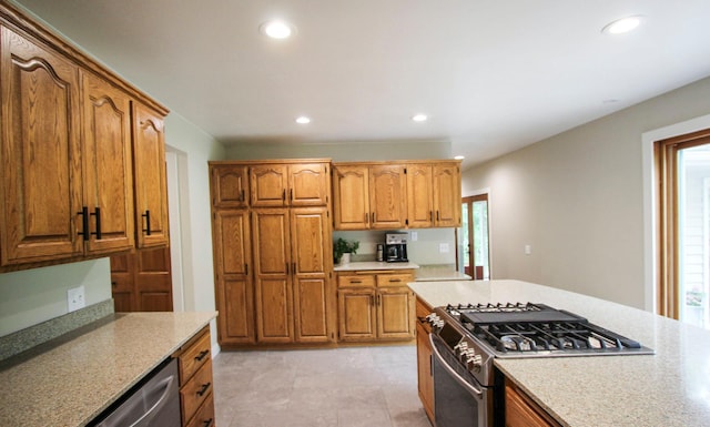 10551 Shore Dr, Merrifield, MN 56465 - kitchen featuring stainless steel appliances, recessed lighting, healthy amount of natural light, brown cabinetry, and light stone counters