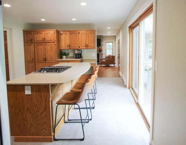 10551 Shore Dr, Merrifield, MN 56465 - kitchen featuring stainless steel gas cooktop, light countertops, recessed lighting, a breakfast bar, and a center island