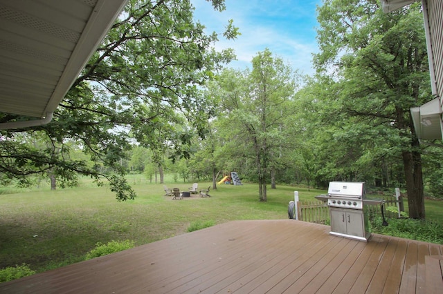 10551 Shore Dr, Merrifield, MN 56465 - wooden deck with a grill, a lawn, a playground, and a fire pit