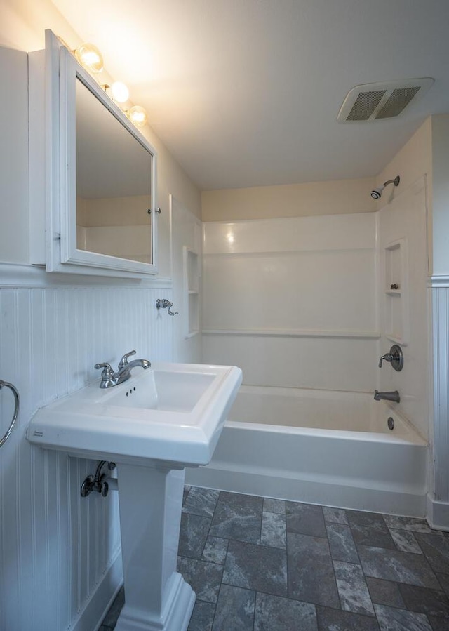 711 2nd St W, Northfield, MN 55057 - full bath with shower / tub combination, stone finish floors, and a sink