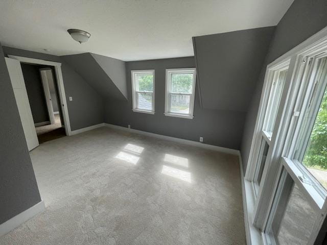 bonus room featuring carpet flooring, vaulted ceiling, and baseboards