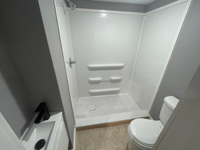 full bath featuring toilet and a stall shower