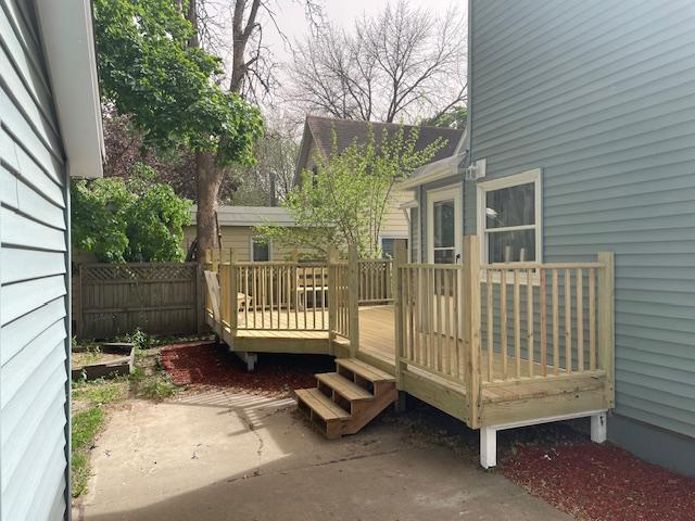 wooden deck featuring a patio area and fence