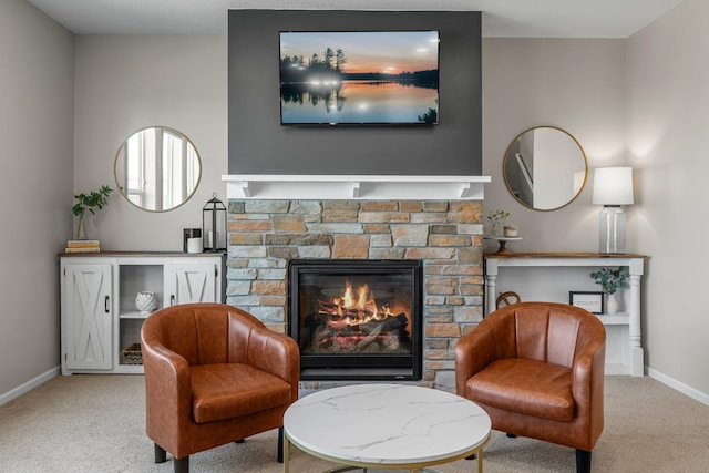 living area with carpet flooring, baseboards, and a stone fireplace