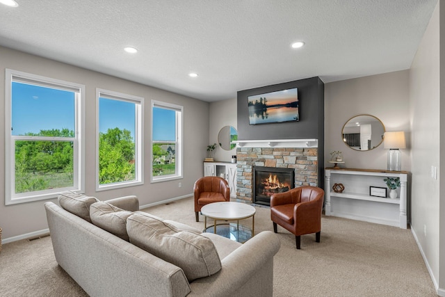 living area featuring carpet flooring, baseboards, a textured ceiling, recessed lighting, and a fireplace