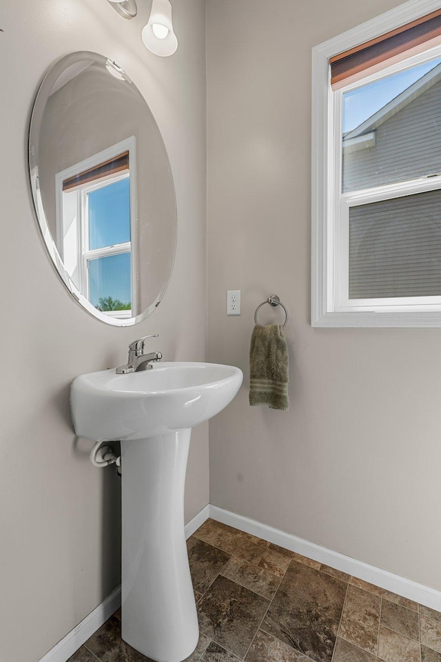 bathroom with baseboards and stone finish flooring