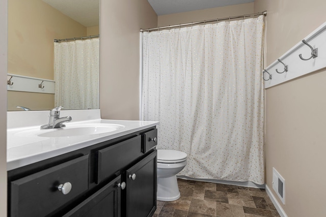 full bath with toilet, vanity, stone finish flooring, and a shower with curtain