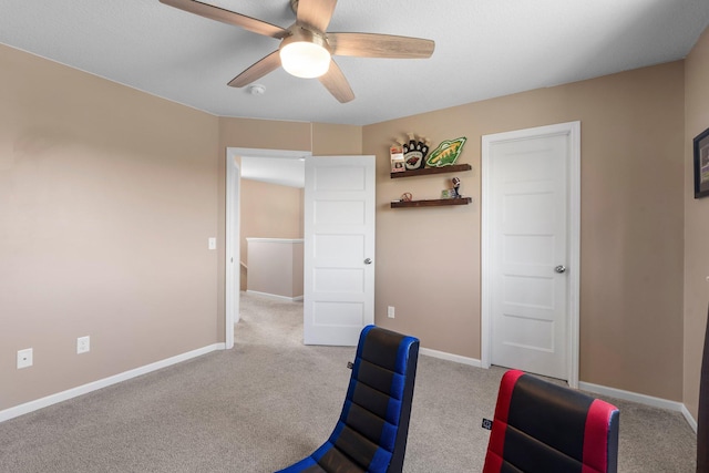 office area with a ceiling fan, carpet, and baseboards