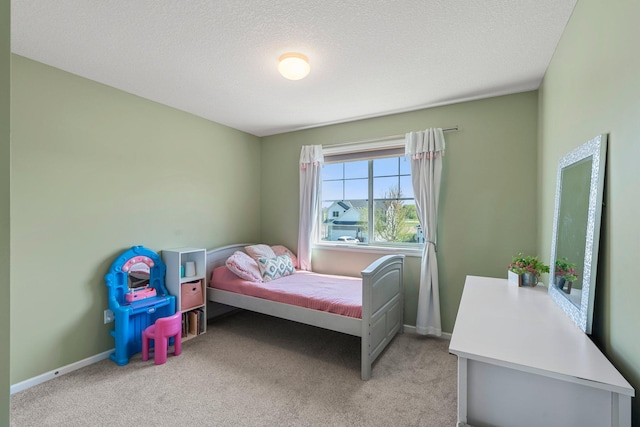 bedroom with light carpet, baseboards, and a textured ceiling