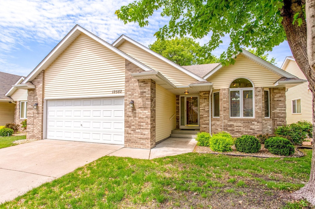 12582 Thrush St NW, Coon Rapids, MN 55448 - single story home with a garage, brick siding, and concrete driveway