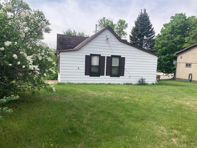 610 7th St, Starbuck, MN 56381 - rear view of property with a lawn and roof with shingles