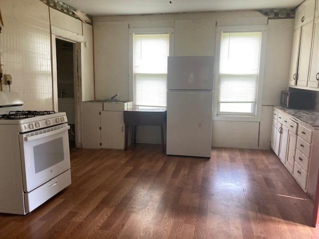 610 7th St, Starbuck, MN 56381 - kitchen featuring white appliances, healthy amount of natural light, and wood finished floors