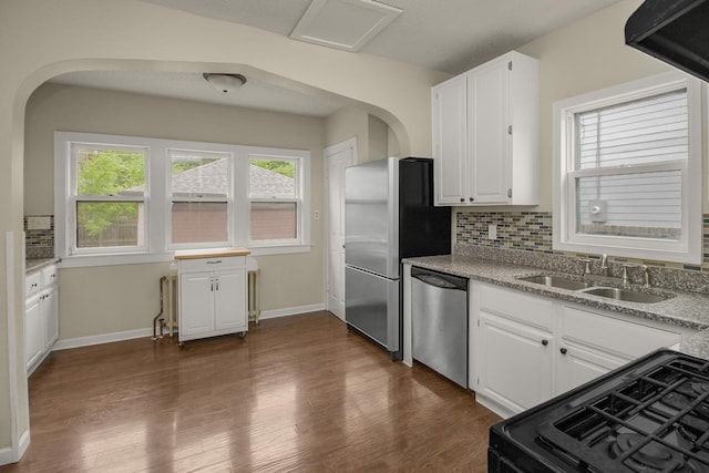 139 Annapolis St E, Saint Paul, MN 55118 - kitchen with stainless steel appliances, arched walkways, a sink, backsplash, and dark wood-type flooring