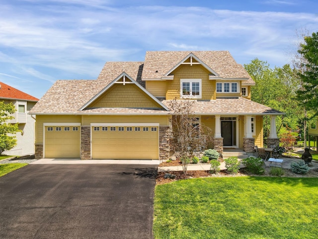 2907 Cougar Path NW, Prior Lake, MN 55372 - craftsman house featuring asphalt driveway, a front lawn, stone siding, and covered porch