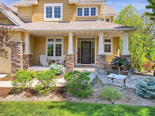 2907 Cougar Path NW, Prior Lake, MN 55372 - property entrance featuring covered porch, stone siding, and roof with shingles