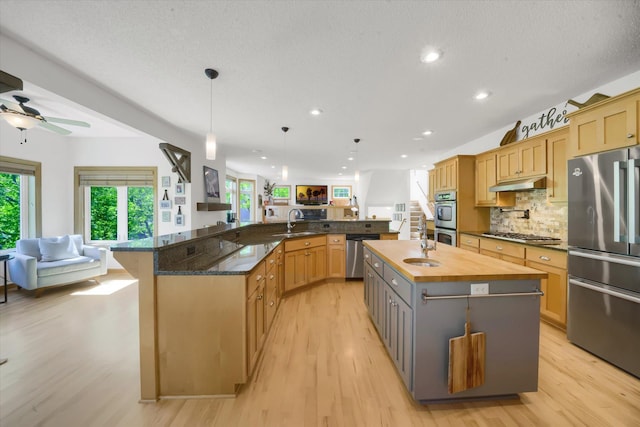 2907 Cougar Path NW, Prior Lake, MN 55372 - kitchen featuring appliances with stainless steel finishes, open floor plan, a sink, a large island, and under cabinet range hood