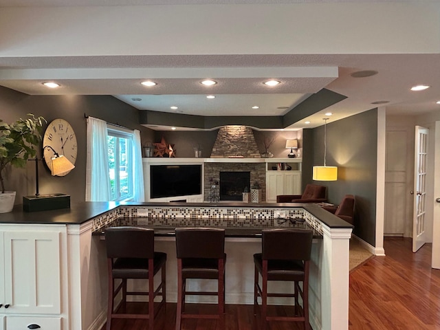 2907 Cougar Path NW, Prior Lake, MN 55372 - kitchen featuring dark countertops, open floor plan, wood finished floors, white cabinetry, and recessed lighting