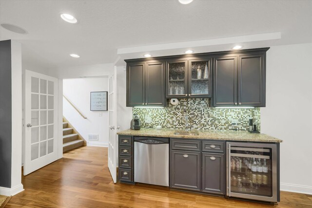 2907 Cougar Path NW, Prior Lake, MN 55372 - indoor bar featuring beverage cooler, stainless steel dishwasher, stairway, decorative backsplash, and recessed lighting