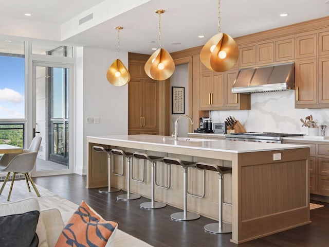 1111 River Pkwy Unit 33A, Minneapolis, MN 55415 - kitchen featuring exhaust hood, a center island with sink, light countertops, a sink, and dark wood finished floors