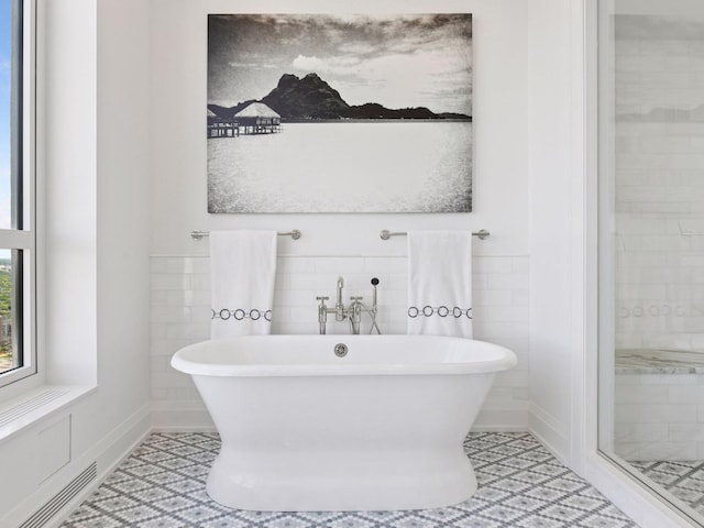 1111 River Pkwy Unit 33A, Minneapolis, MN 55415 - full bath featuring a freestanding tub, tile walls, a shower stall, and tile patterned flooring