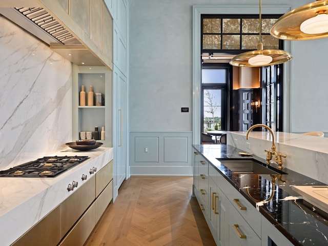 1111 River Pkwy Unit 33A, Minneapolis, MN 55415 - kitchen with a sink, wall chimney exhaust hood, stone counters, a towering ceiling, and a wainscoted wall