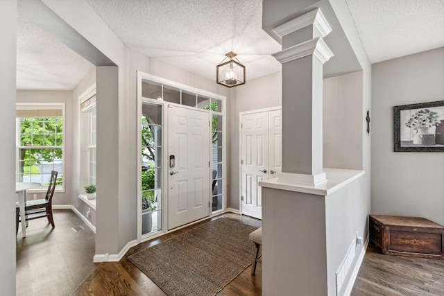 18764 Farmstead Cir, Eden Prairie, MN 55347 - foyer entrance featuring a textured ceiling, baseboards, dark wood-type flooring, and decorative columns