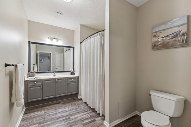 18764 Farmstead Cir, Eden Prairie, MN 55347 - full bath featuring wood finished floors, toilet, vanity, baseboards, and a textured ceiling