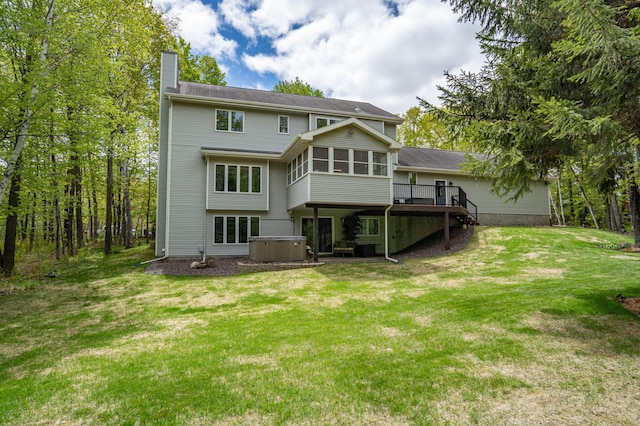 4975 Maribe Dr, Hermantown, MN 55811 - rear view of house featuring a hot tub, a chimney, a deck, a sunroom, and a lawn